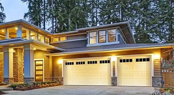 Amarr Lincoln raised-panel garage doors in almond with a row of top windows on a craftsman home